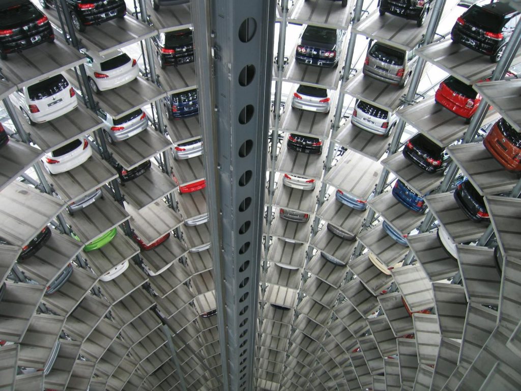 A vertical view of a spiral multi-storey car park filled with vehicles.